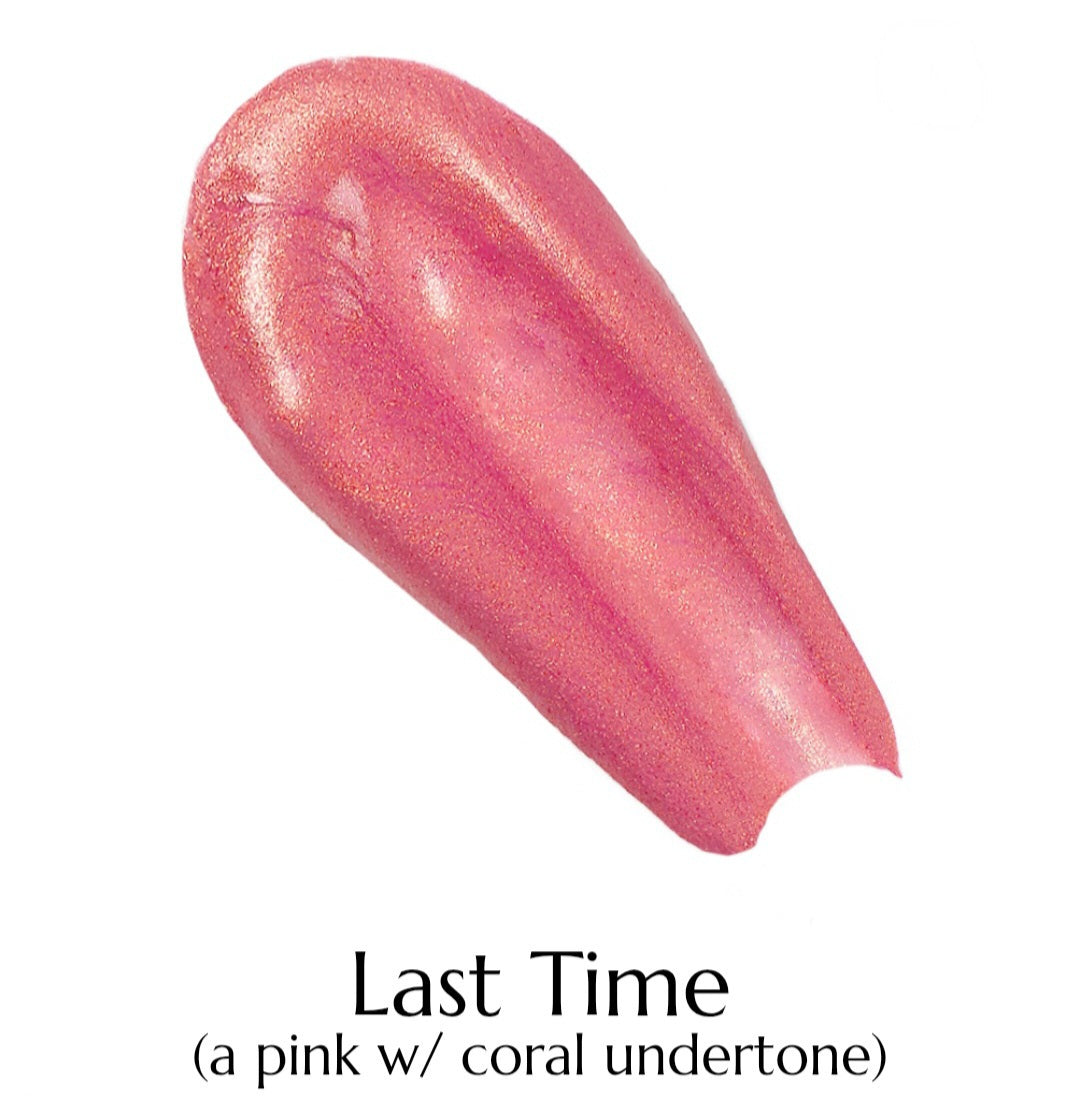 Pink lip gloss with coral undertone on a white background